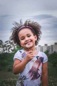 girl holding dandelion flower